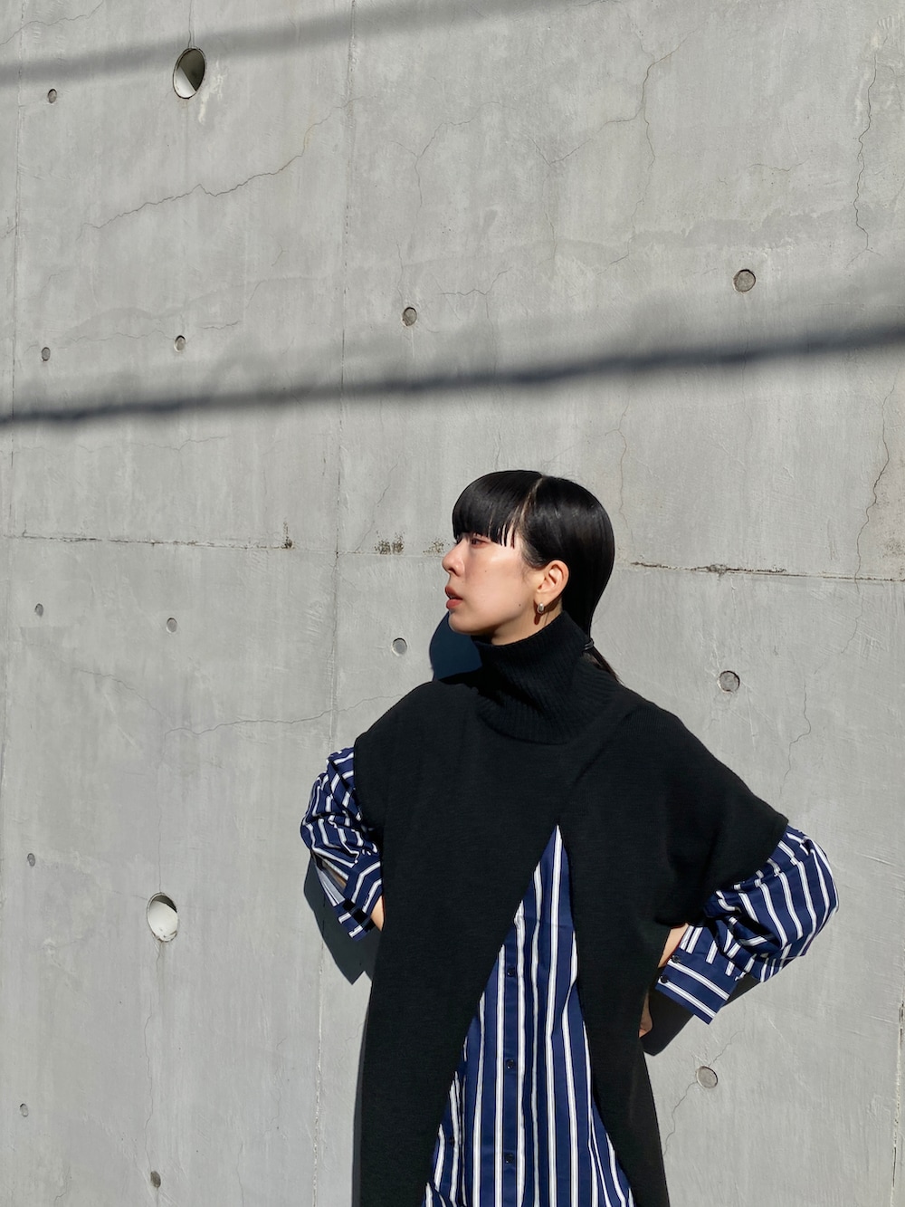 ブラック系のニット/セーター、ブルー系のシャツ/ブラウス、ブルー系のその他パンツを着用したレディースの秋コーディネートの4枚目の写真