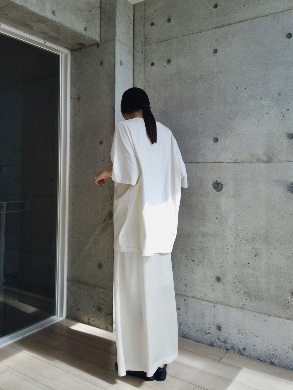 ホワイト系のスカート、ホワイト系のTシャツ/カットソー、ブラック系のショルダーバッグを着用したレディースの春コーディネートの4枚目の写真