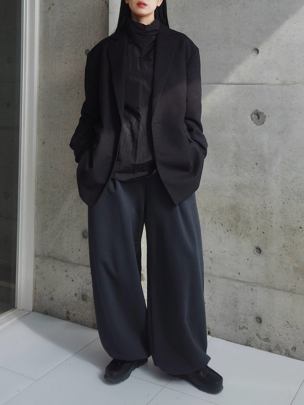 ブラック系のテーラードジャケット、ブルー系のその他パンツ、ブラック系のシャツ/ブラウスを着用したレディースの春コーディネートの2枚目の写真