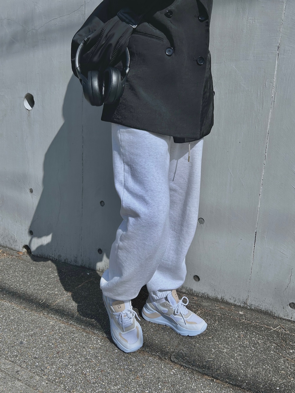 ブラック系のテーラードジャケット、ブラック系のショルダーバッグ、グレー系のスウェットパンツを着用したレディースの春コーディネートの5枚目の写真