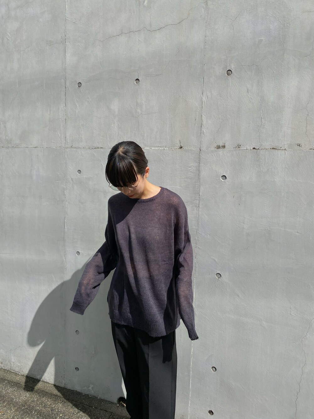 ブラック系のニット/セーター、ブラック系のスラックス、グレー系のスニーカーを着用したレディースの秋コーディネートの2枚目の写真