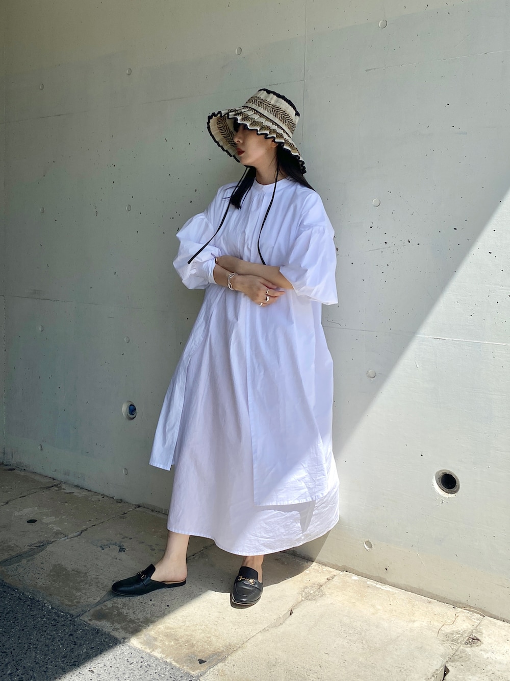 ブラック系のその他シューズ、ホワイト系のワンピース、ブラック系のハットを着用したレディースの夏コーディネートの2枚目の写真
