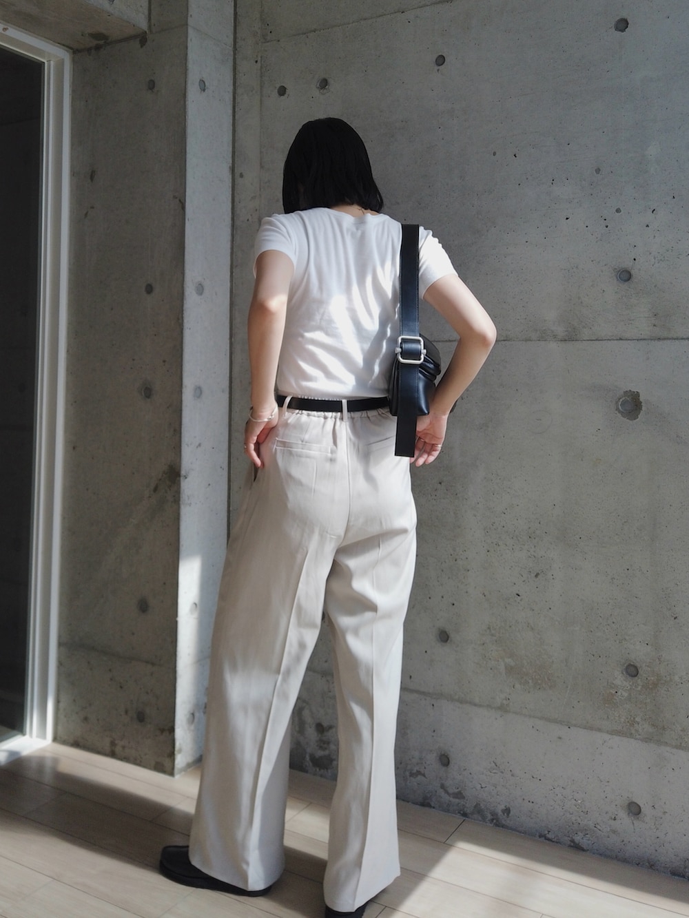ベージュ系のその他パンツ、ホワイト系のTシャツ/カットソー、ブラック系のショルダーバッグを着用したレディースの夏コーディネートの3枚目の写真