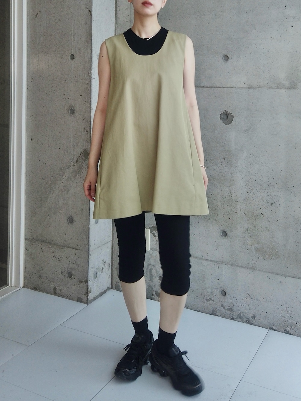 ブラック系のデニムパンツ、ベージュ系のその他トップス、ブラック系のスニーカーを着用したレディースの夏コーディネートの2枚目の写真