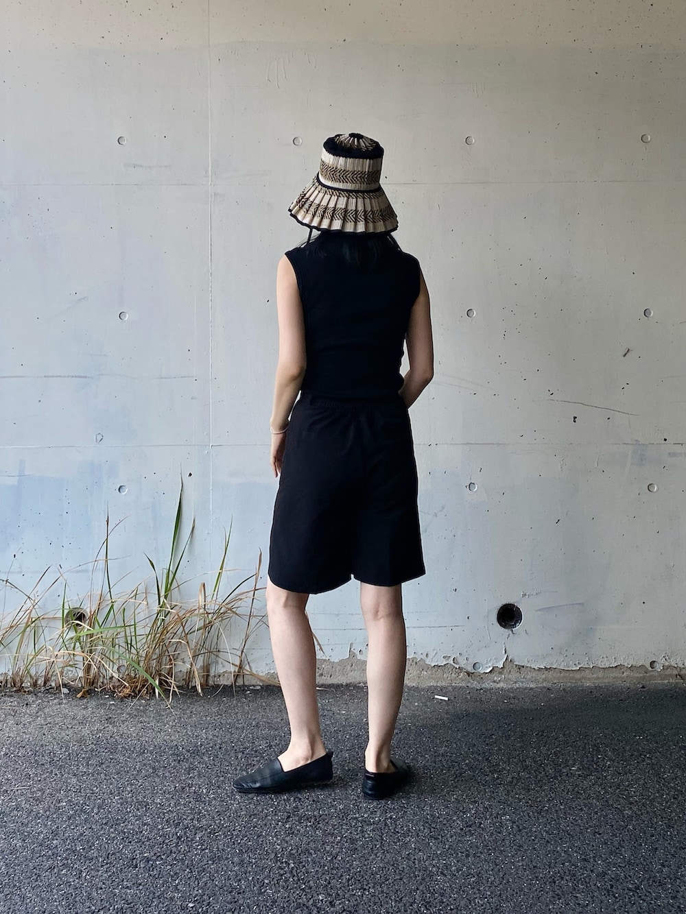 ブラック系のTシャツ/カットソー、ブラック系のその他パンツ、ブラック系のハットを着用したレディースの春コーディネートの3枚目の写真