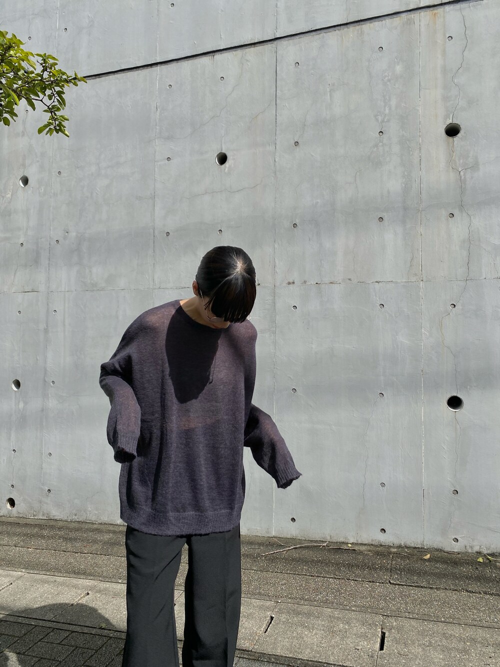 ブラック系のニット/セーター、ブラック系のスラックス、グレー系のスニーカーを着用したレディースの秋コーディネートの3枚目の写真