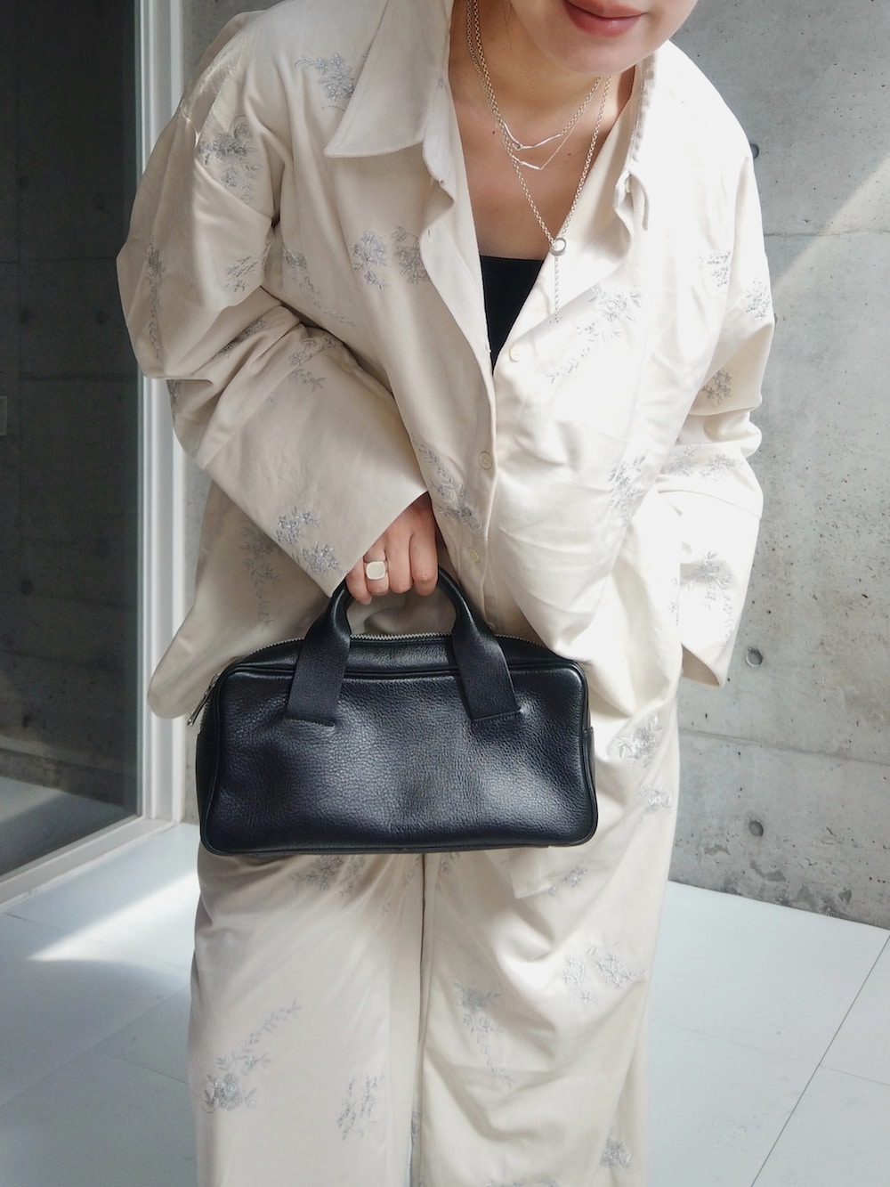 ブラック系のハンドバッグ、ホワイト系のシャツ/ブラウス、ホワイト系のその他パンツを着用したレディースの秋コーディネートの2枚目の写真