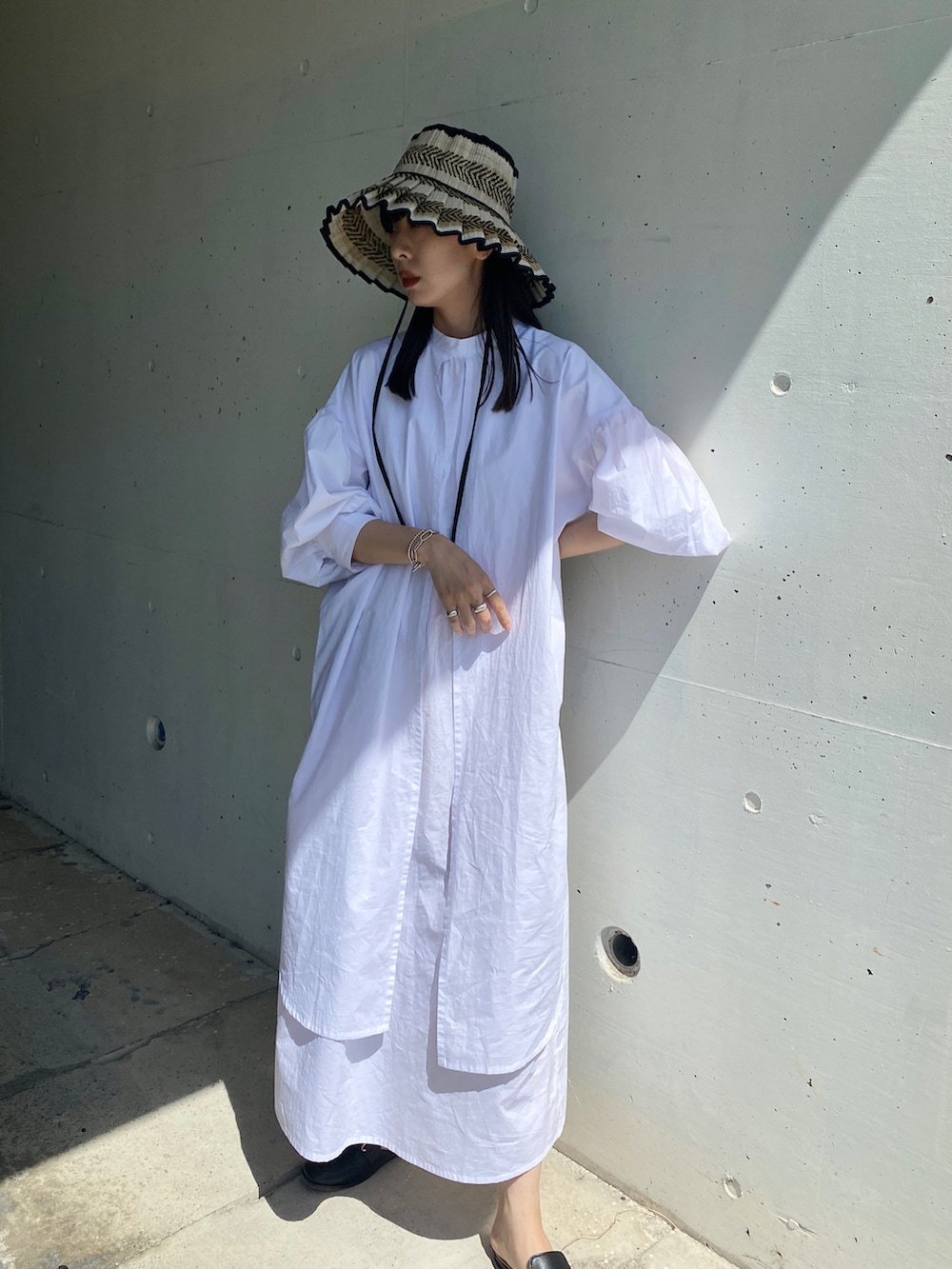 ブラック系のその他シューズ、ホワイト系のワンピース、ブラック系のハットを着用したレディースの夏コーディネートの4枚目の写真