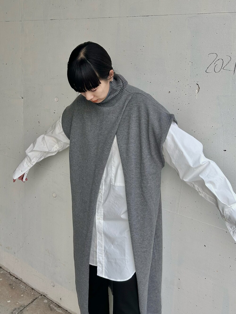 グレー系のニット/セーター、ホワイト系のシャツ/ブラウス、ブラック系のブーツを着用したレディースの冬コーディネートの4枚目の写真