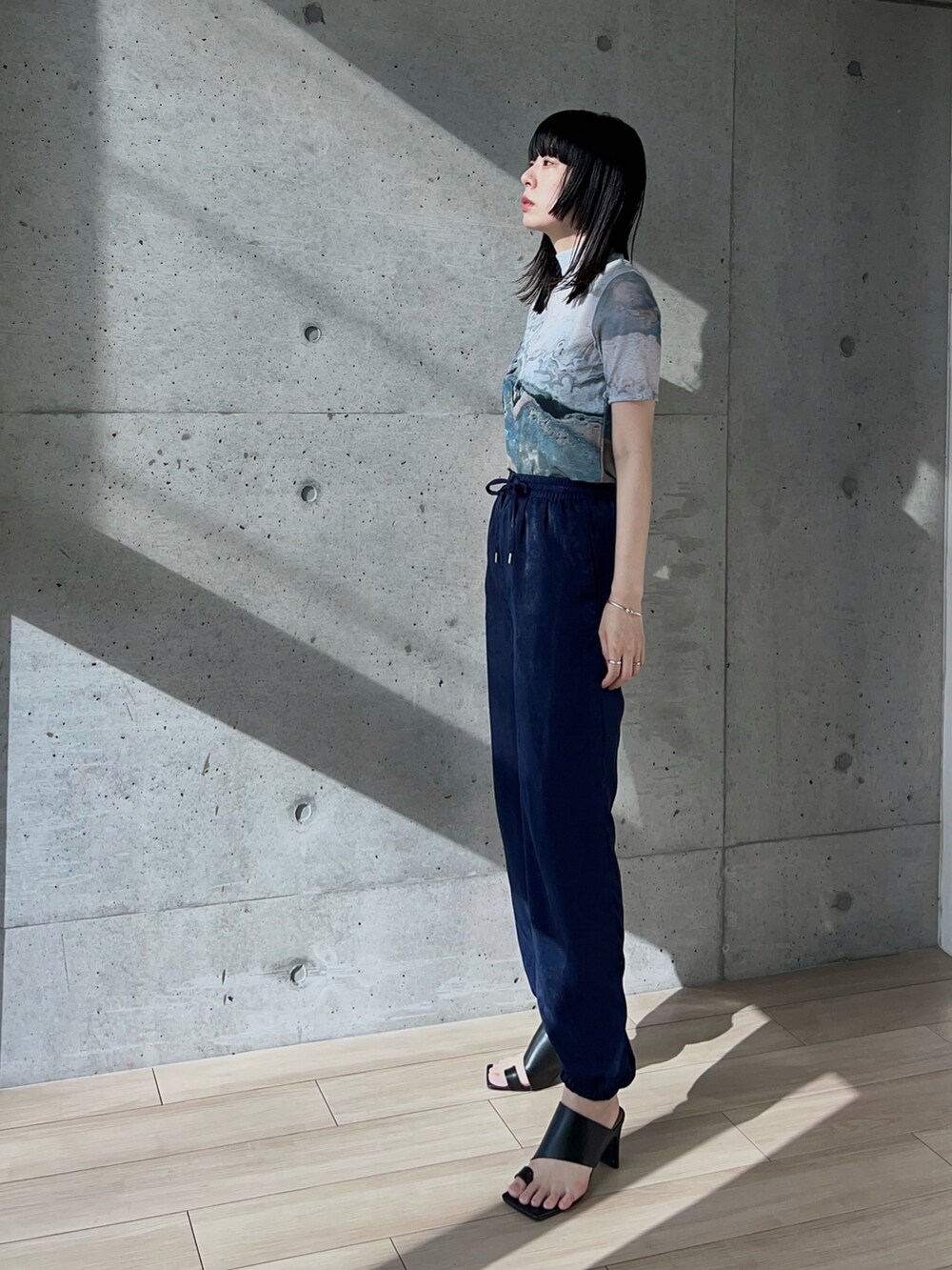 ブルー系のその他パンツ、グレー系のTシャツ/カットソー、ブラック系のサンダルを着用したレディースの夏コーディネートの2枚目の写真