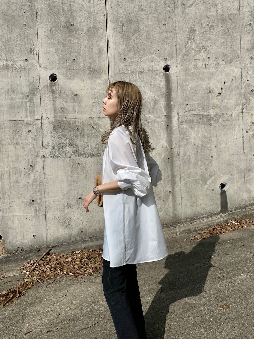 ブラック系のデニムパンツ、グリーン系のサンダル、ホワイト系のシャツ/ブラウスを着用したレディースの春コーディネートの2枚目の写真