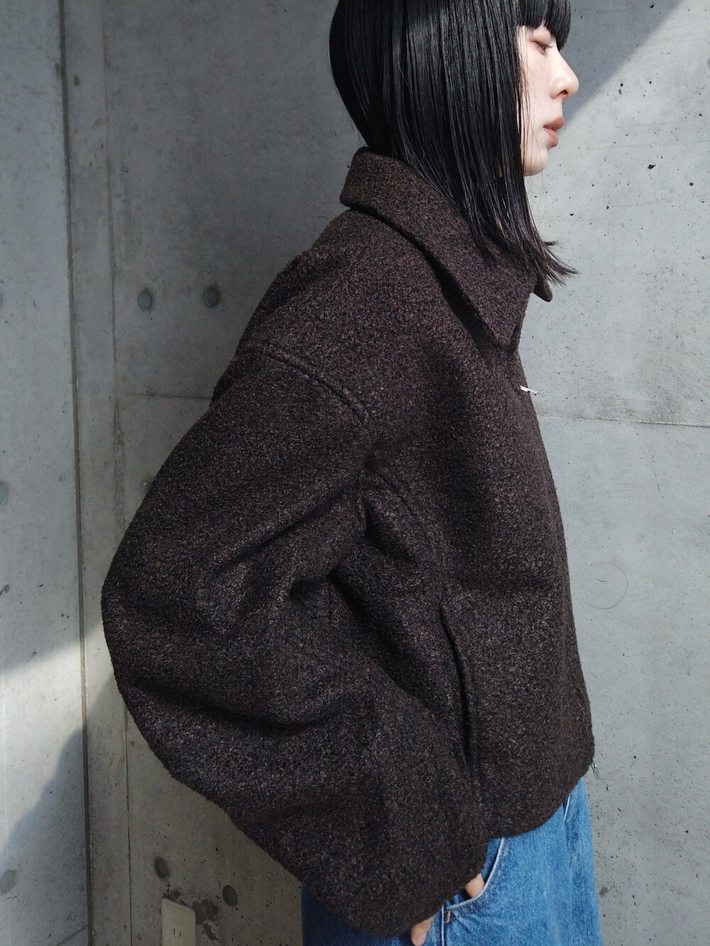 ブラック系のTシャツ/カットソー、ブルー系のデニムパンツ、ブラック系のスニーカーを着用したレディースの秋コーディネートの3枚目の写真