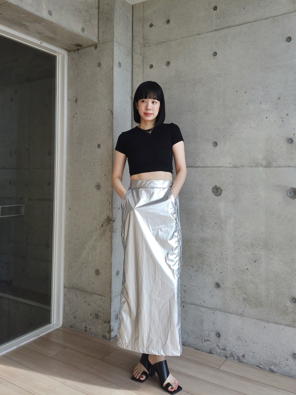 シルバー系のスカート、ブラック系のサンダルを着用したレディースの夏コーディネートの2枚目の写真