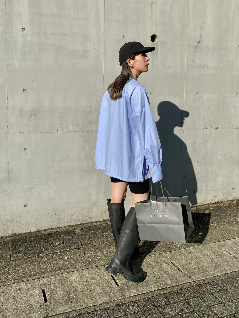 ブルー系のシャツ/ブラウス、ブラック系のスラックス、ブラック系のブーツを着用したレディースの秋コーディネートの4枚目の写真