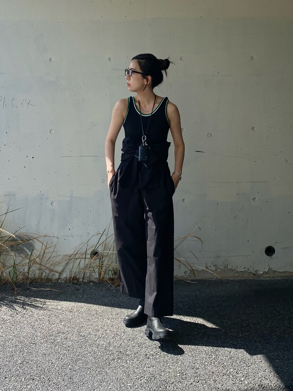 ブラック系のつなぎ/オールインワン、ブラック系のタンクトップ、ブラック系のブーツを着用したレディースの春コーディネートの4枚目の写真