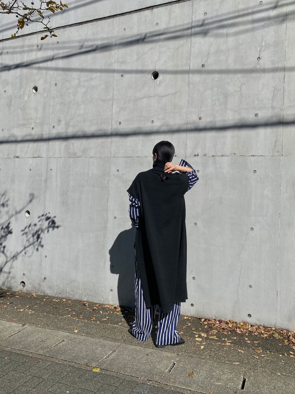 ブラック系のニット/セーター、ブルー系のシャツ/ブラウス、ブルー系のその他パンツを着用したレディースの秋コーディネートの3枚目の写真