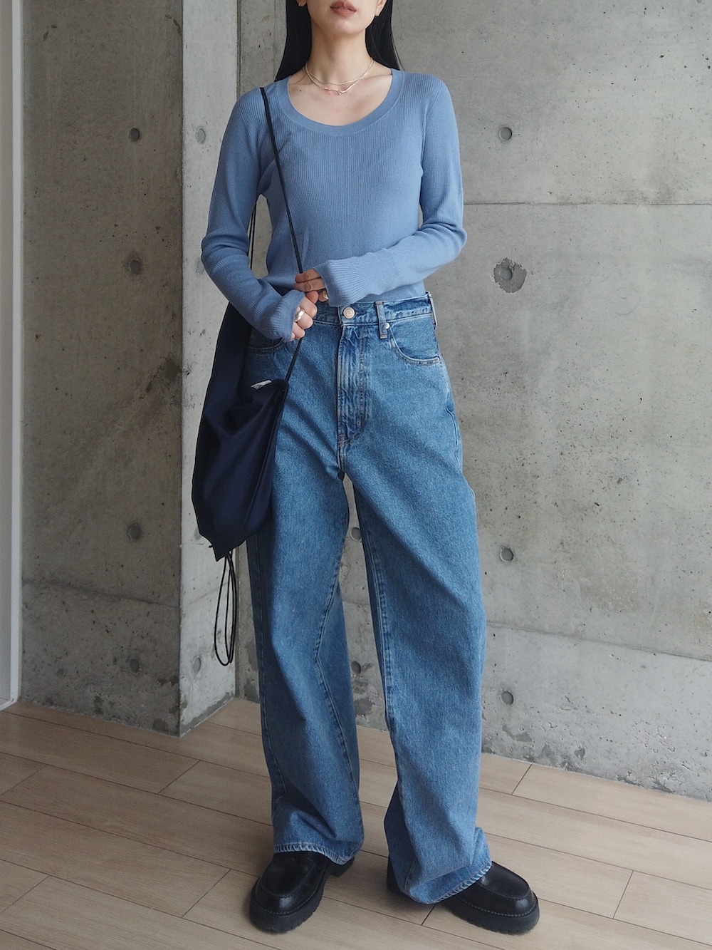 ブルー系のデニムパンツ、ブラック系のローファー、ブルー系のバックパック/リュックを着用したレディースの春コーディネートの2枚目の写真