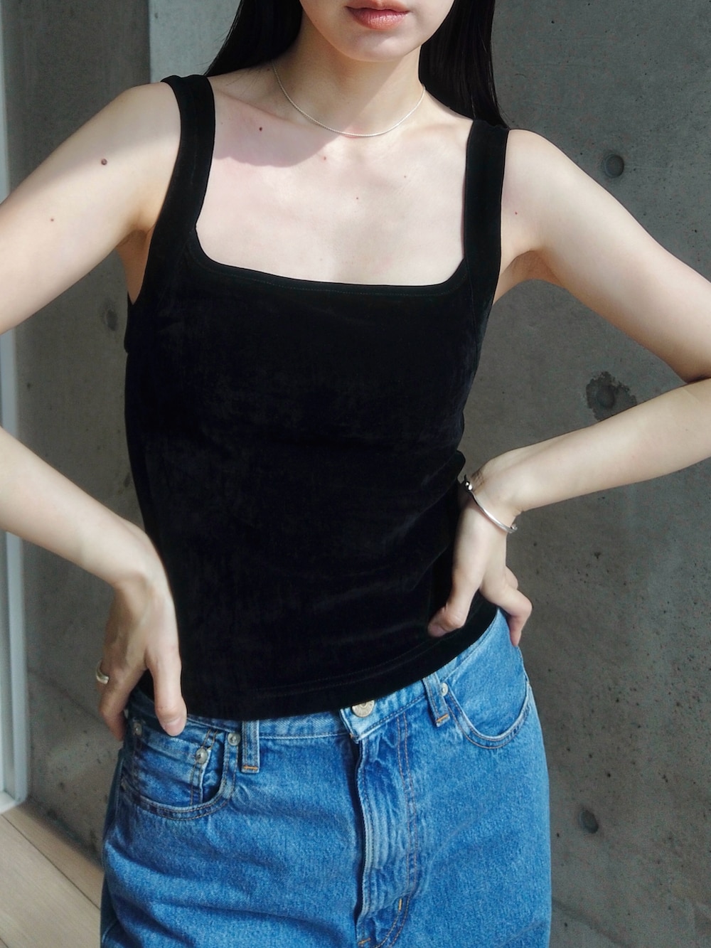 ブルー系のデニムパンツ、ブラック系のショルダーバッグ、ブラック系のブーツを着用したレディースの春コーディネートの2枚目の写真