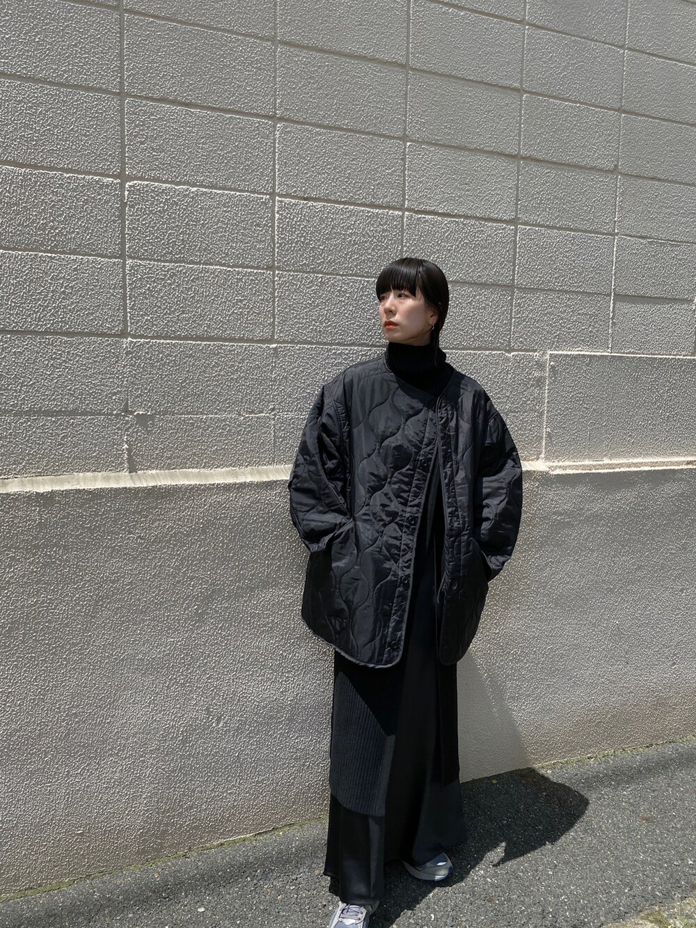 ブラック系のニット/セーター、グレー系のスニーカー、ブラック系のスカートを着用したレディースの夏コーディネートの4枚目の写真