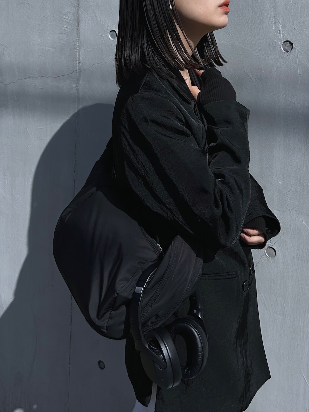 ブラック系のテーラードジャケット、ブラック系のショルダーバッグ、グレー系のスウェットパンツを着用したレディースの春コーディネートの3枚目の写真