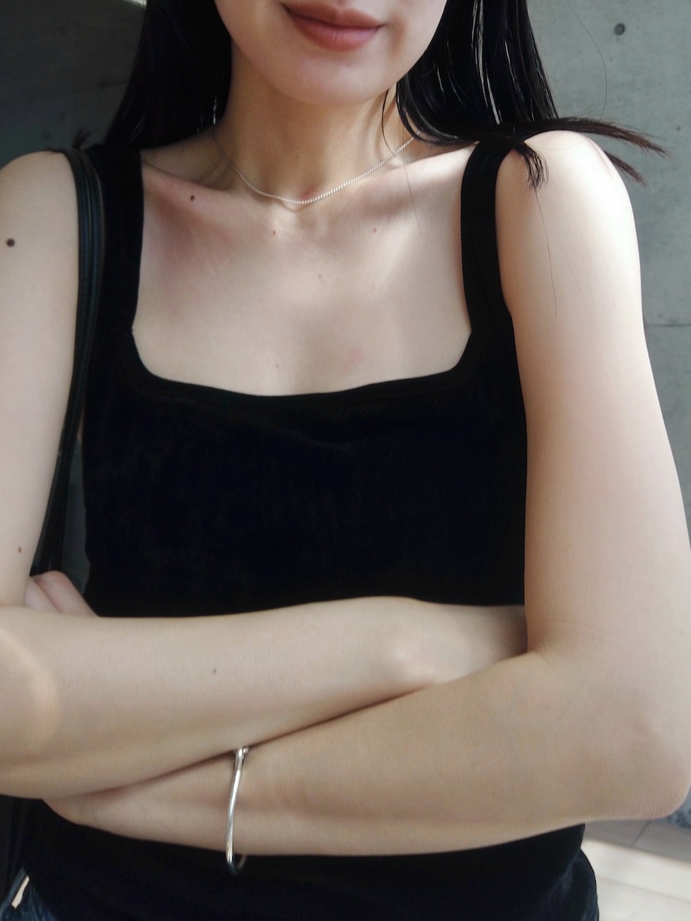 ブルー系のデニムパンツ、ブラック系のショルダーバッグ、ブラック系のブーツを着用したレディースの春コーディネートの3枚目の写真