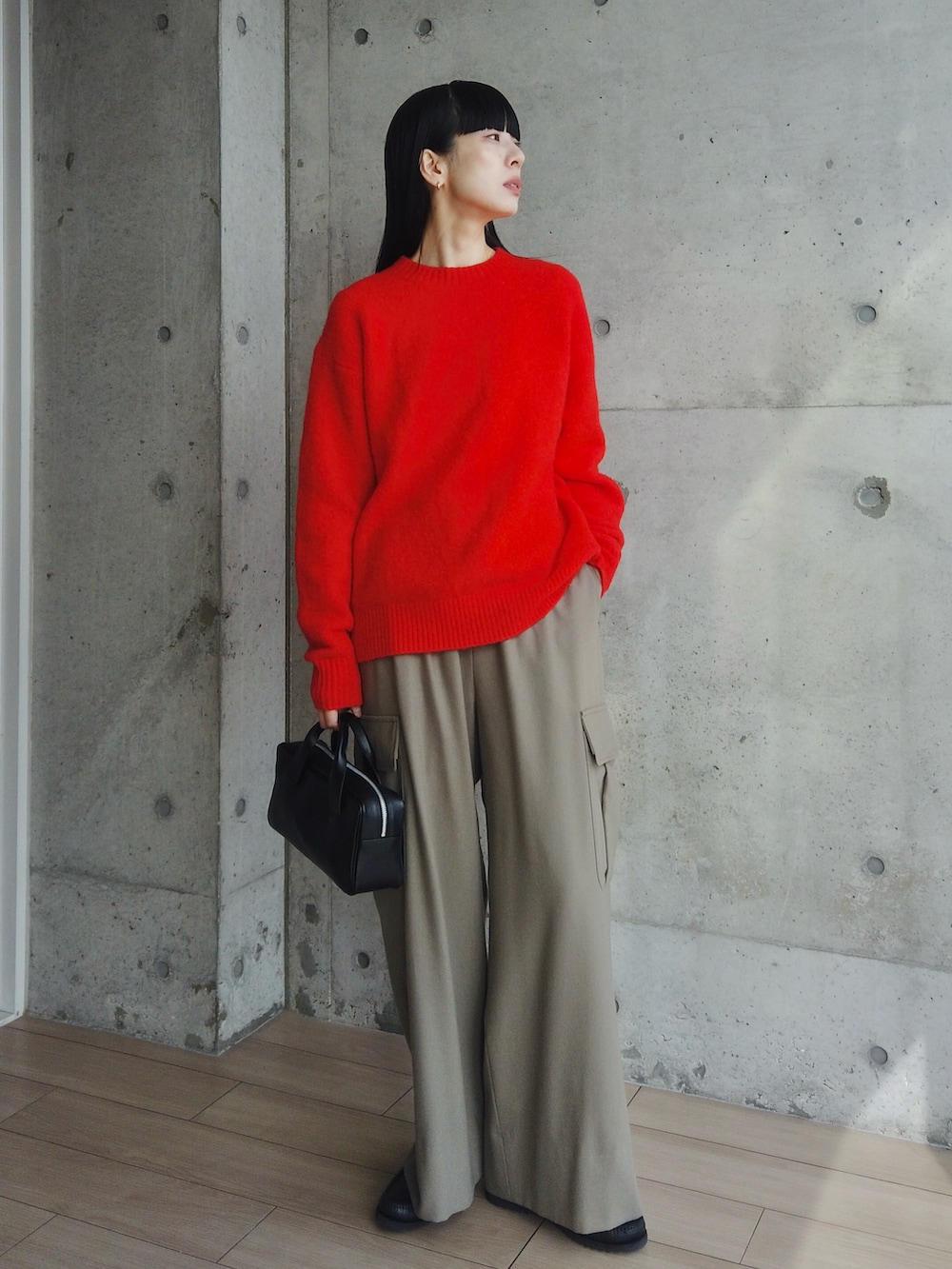 ブラック系のハンドバッグ、グリーン系のカーゴパンツ、ブラック系のモカシン/デッキシューズを着用したレディースの冬コーディネートの2枚目の写真