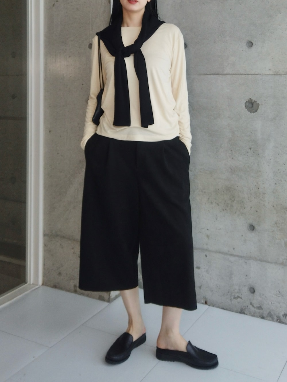 ブラック系のその他パンツ、ブラック系のモカシン/デッキシューズ、イエロー系のトップスを着用したレディースの春コーディネートの2枚目の写真