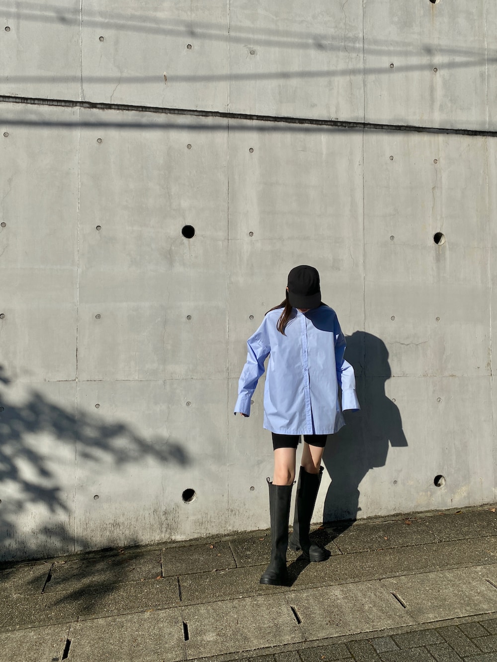 ブルー系のシャツ/ブラウス、ブラック系のスラックス、ブラック系のブーツを着用したレディースの秋コーディネートの3枚目の写真