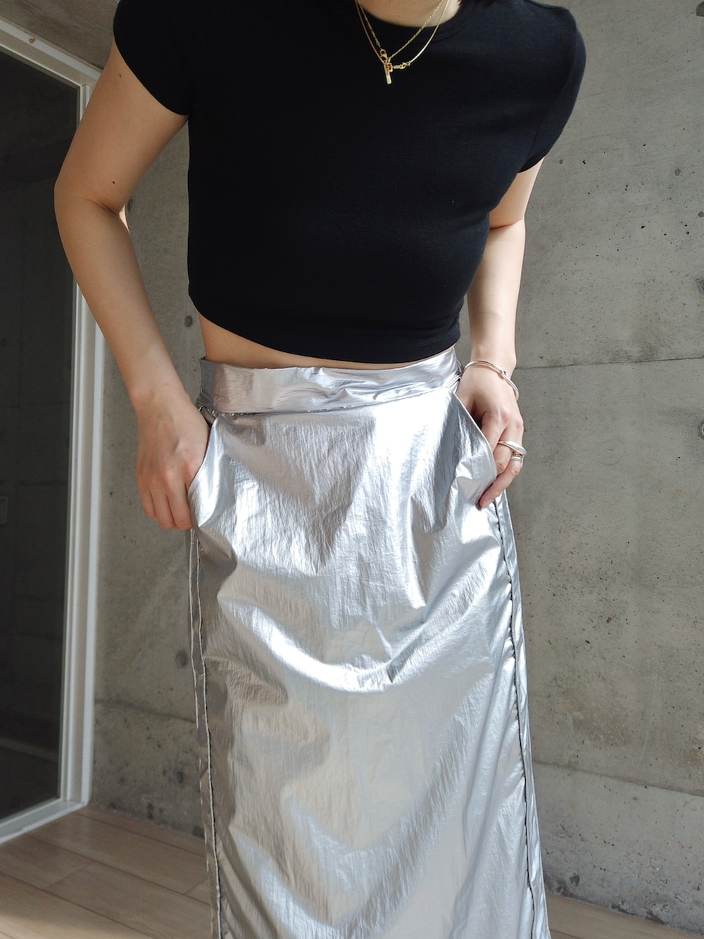 シルバー系のスカート、ブラック系のサンダルを着用したレディースの夏コーディネートの3枚目の写真