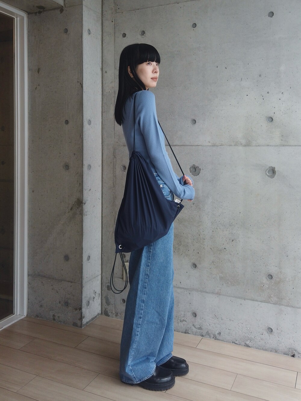 ブルー系のデニムパンツ、ブラック系のローファー、ブルー系のバックパック/リュックを着用したレディースの春コーディネートの3枚目の写真