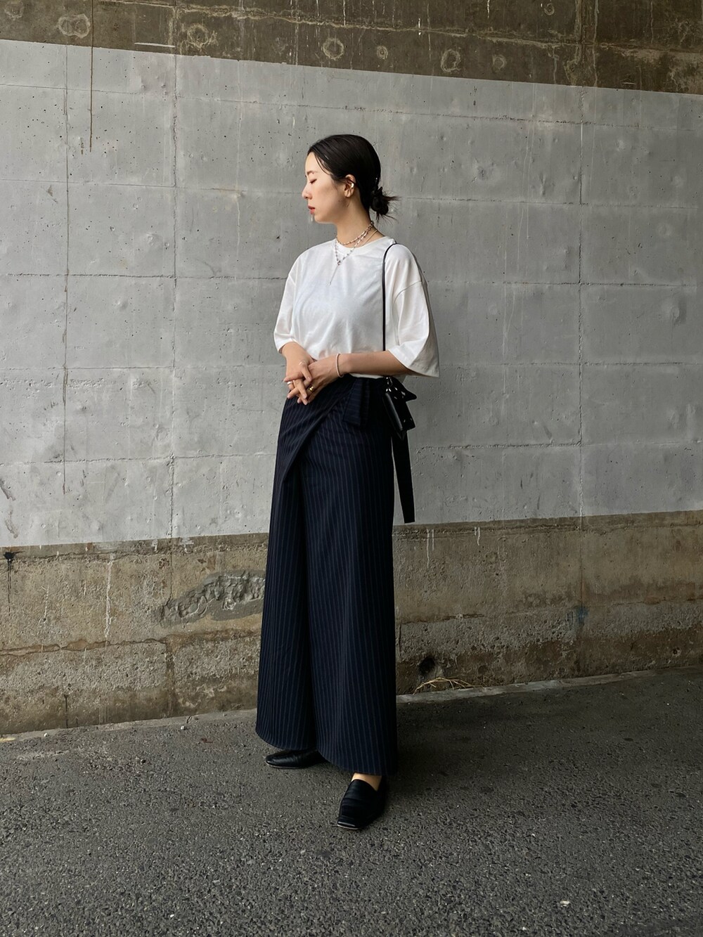 ホワイト系のTシャツ/カットソー、ブラック系のコインケース、ブラック系のキーケース/キーアクセサリーを着用したレディースの春コーディネートの2枚目の写真