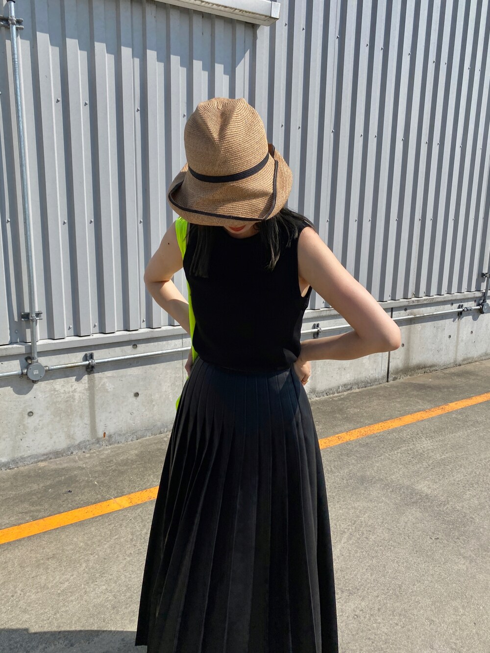 ブラック系のタンクトップ、ブラック系のスカート、ホワイト系のスニーカーを着用したレディースの夏コーディネートの4枚目の写真