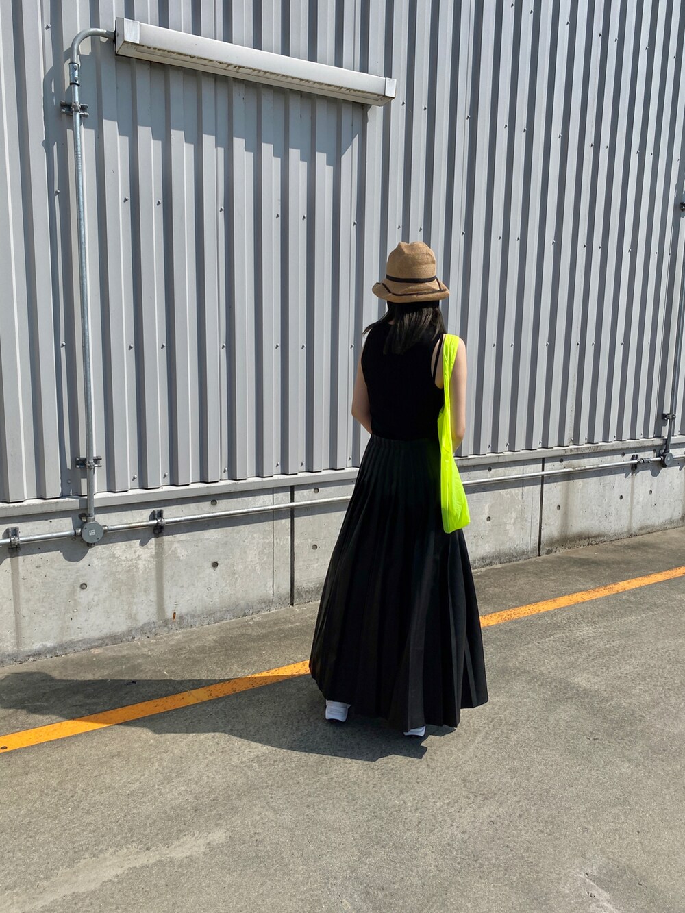 ブラック系のタンクトップ、ブラック系のスカート、ホワイト系のスニーカーを着用したレディースの夏コーディネートの3枚目の写真