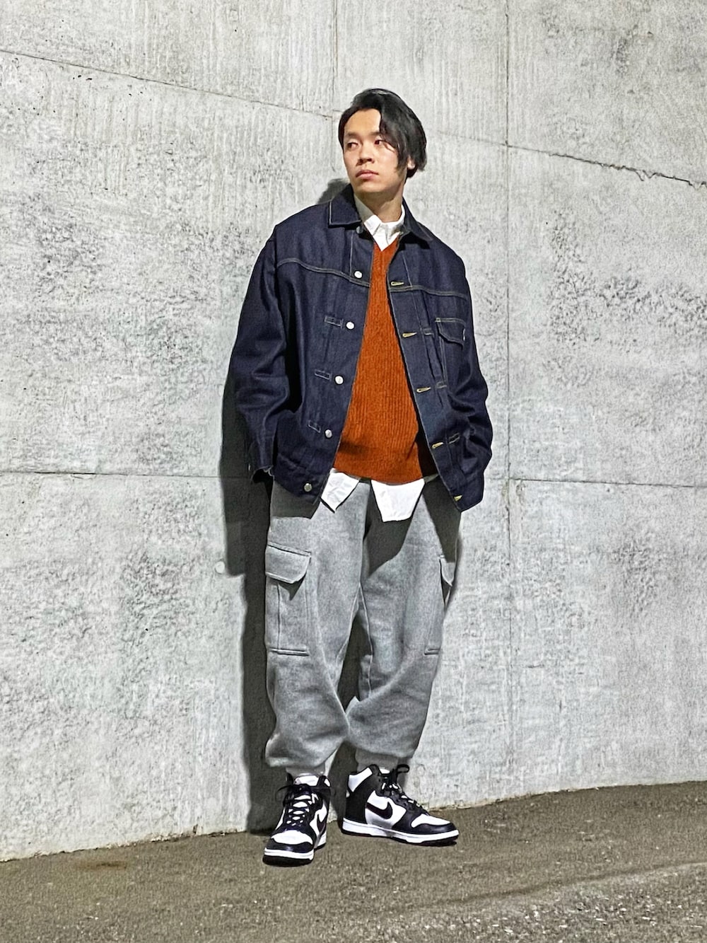 ブルー系のデニムジャケット、オレンジ系のベスト、グレー系のその他パンツを着用したメンズの春コーディネートの2枚目の写真