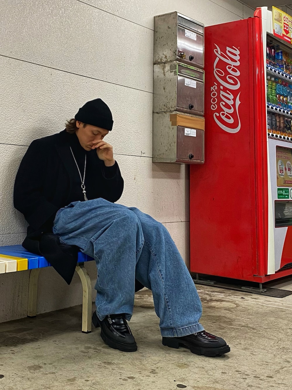 ブラック系のチェスターコート、ブルー系のデニムパンツ、ブラック系のローファーを着用したメンズの春コーディネートの3枚目の写真