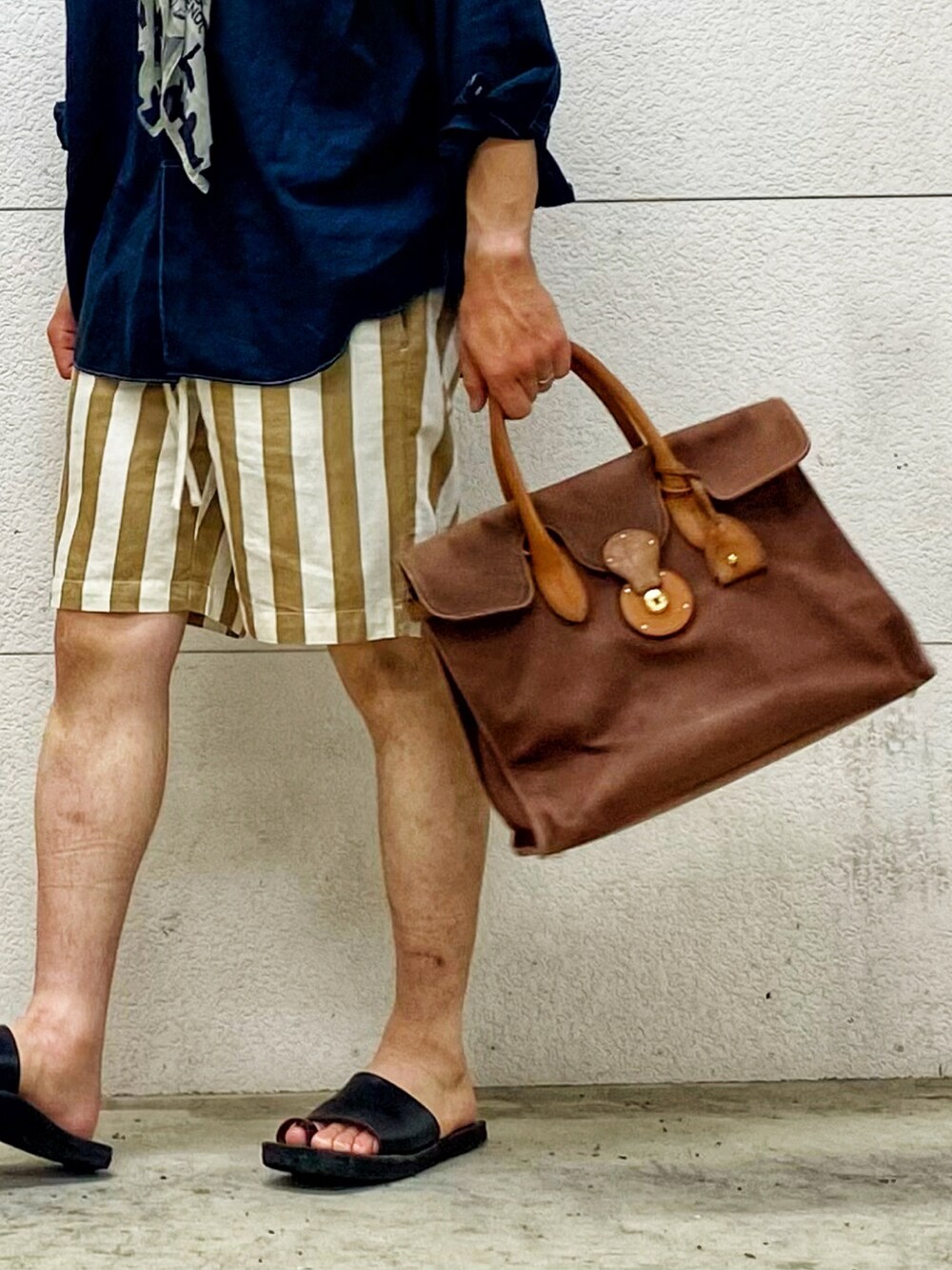 ブラック系のサンダル、ブラウン系のハンドバッグ、ベージュ系のその他パンツを着用したメンズの秋コーディネートの2枚目の写真