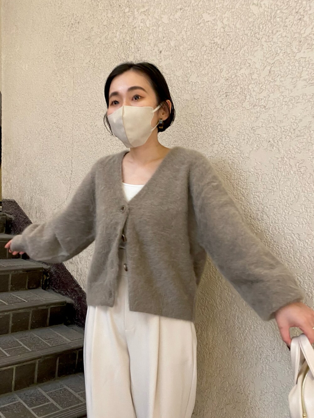 ブラウン系のカーディガン/ボレロ、ホワイト系のボストンバッグ、ホワイト系のデニムパンツを着用したレディースの秋コーディネートの3枚目の写真