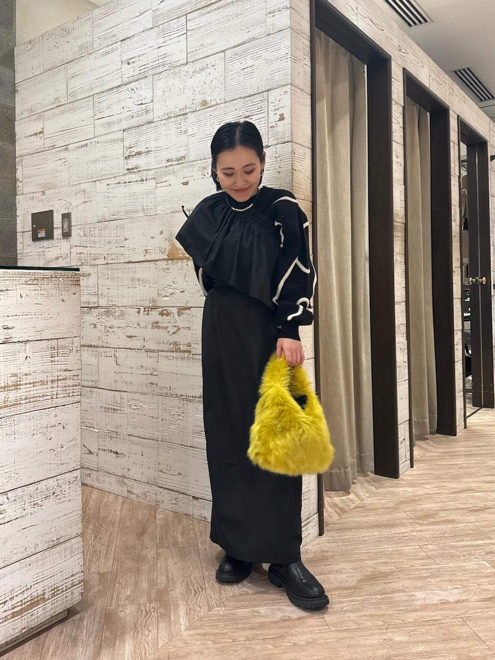 ブラック系のニット/セーター、ブラック系のスカートを着用したレディースの秋コーディネートの3枚目の写真