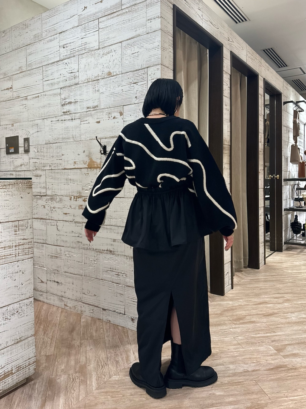 ブラック系のニット/セーター、ブラック系のスカートを着用したレディースの秋コーディネートの2枚目の写真