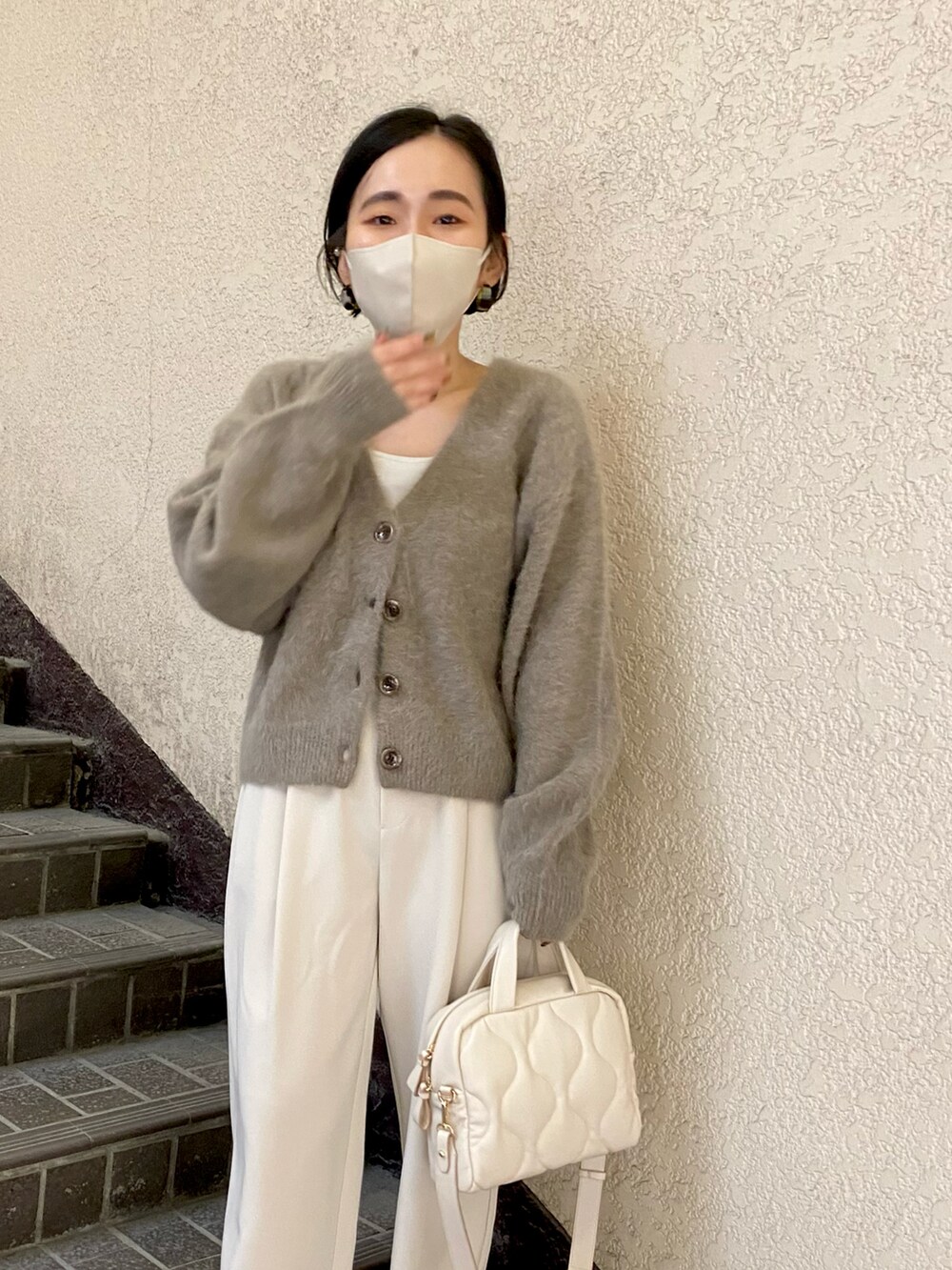 ブラウン系のカーディガン/ボレロ、ホワイト系のボストンバッグ、ホワイト系のデニムパンツを着用したレディースの秋コーディネートの4枚目の写真