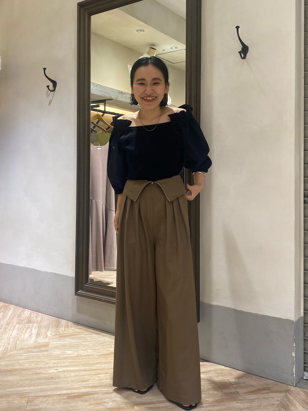 ブラック系のニット/セーター、ブラウン系のパンツ、ブラック系のサンダルを着用したレディースの夏コーディネートの3枚目の写真