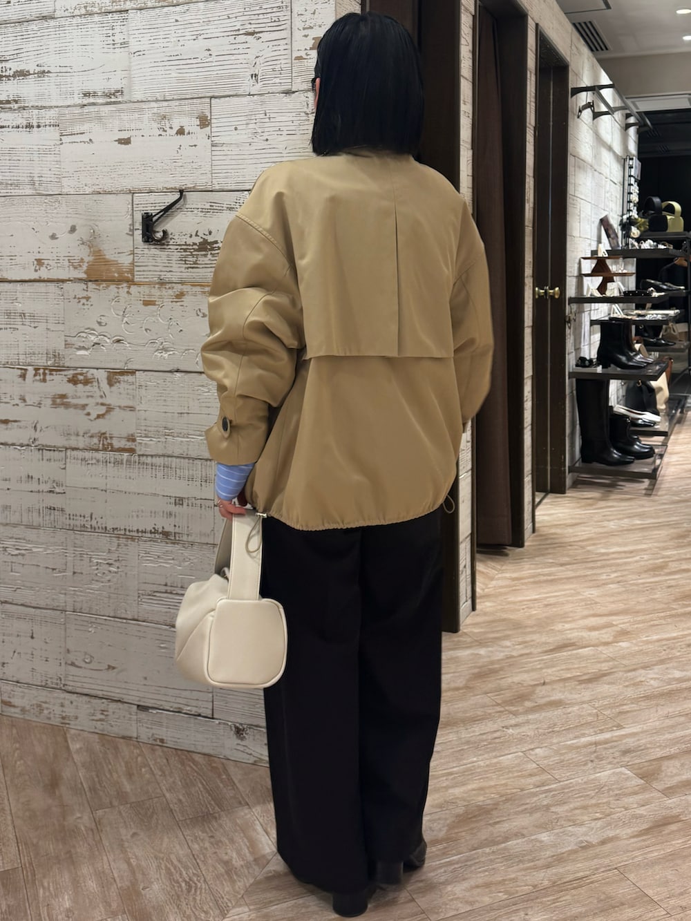 ブラック系のその他パンツ、ホワイト系のハンドバッグ、ブラック系のブーツを着用したレディースの冬コーディネートの4枚目の写真