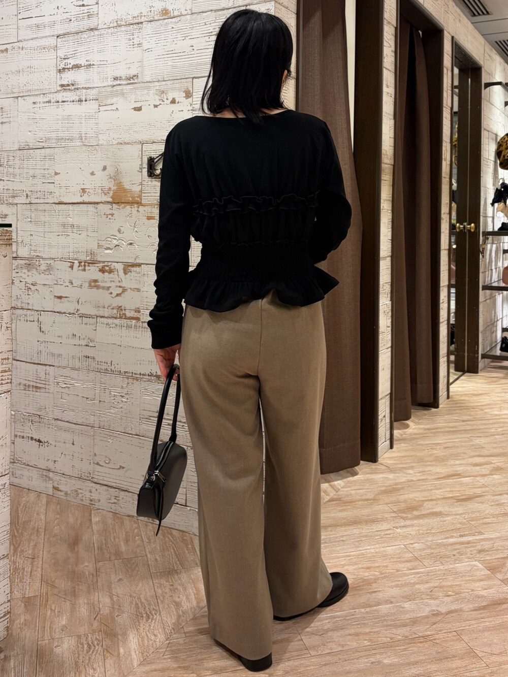 ブラック系のTシャツ/カットソー、ベージュ系のその他パンツ、ブラック系のショルダーバッグを着用したレディースの秋コーディネートの3枚目の写真