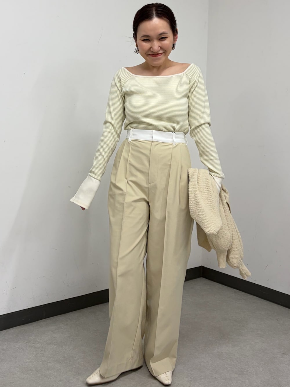 ベージュ系のカーディガン/ボレロ、ベージュ系のその他パンツ、グリーン系のTシャツ/カットソーを着用したレディースの冬コーディネートの2枚目の写真