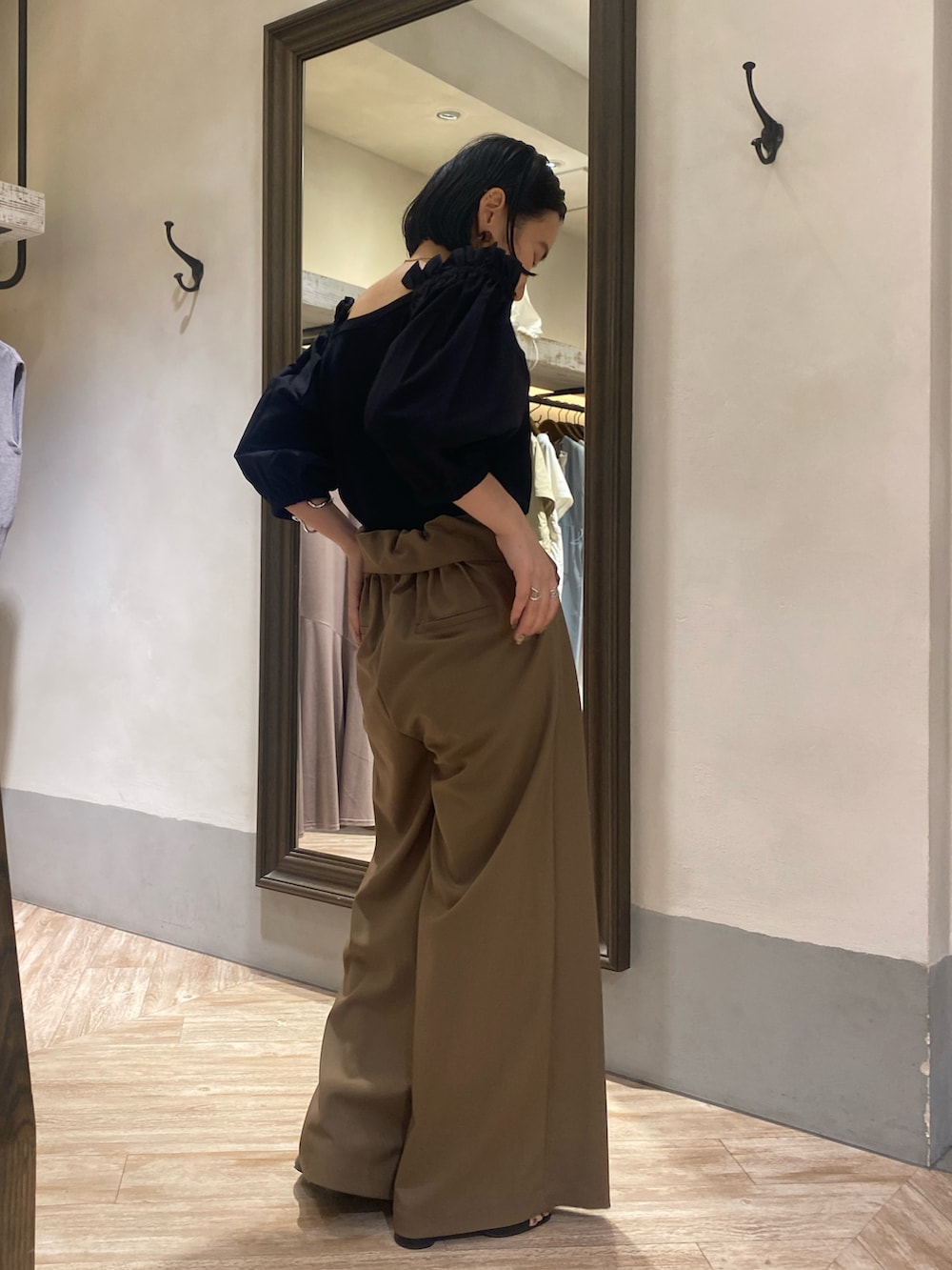 ブラック系のニット/セーター、ブラウン系のパンツ、ブラック系のサンダルを着用したレディースの夏コーディネートの2枚目の写真