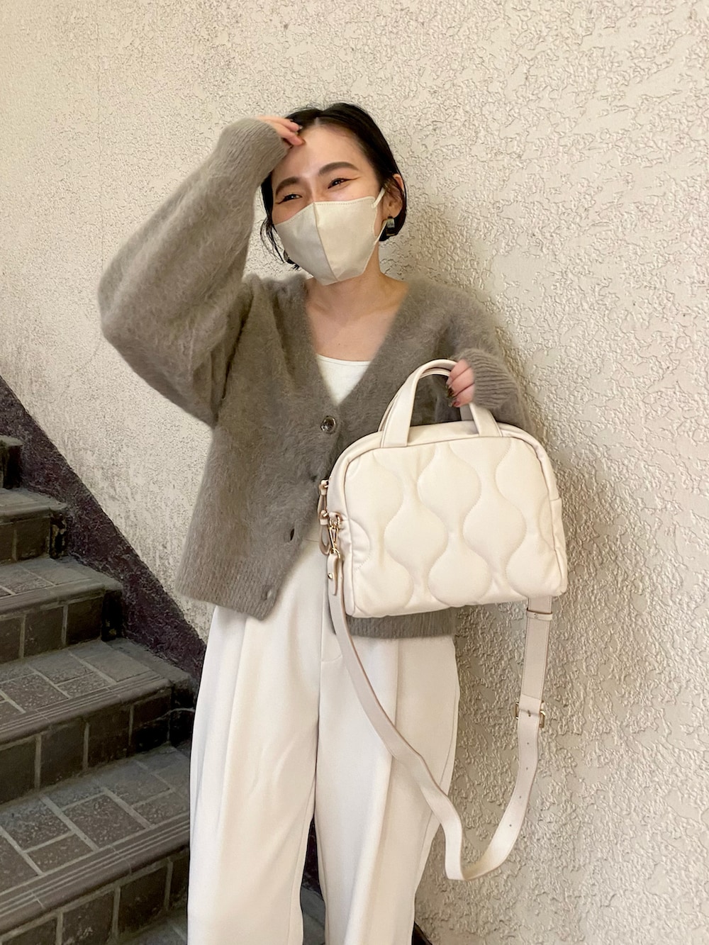 ブラウン系のカーディガン/ボレロ、ホワイト系のボストンバッグ、ホワイト系のデニムパンツを着用したレディースの秋コーディネートの5枚目の写真