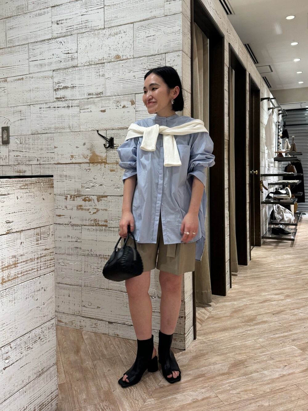 ブラック系のブーツ、ベージュ系のその他パンツ、ブルー系のシャツ/ブラウスを着用したレディースの春コーディネートの2枚目の写真