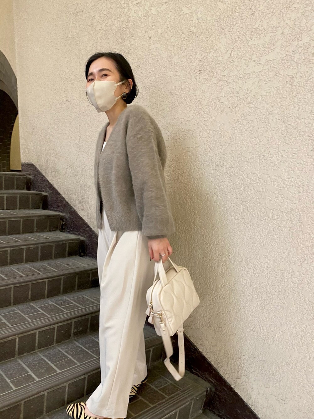 ブラウン系のカーディガン/ボレロ、ホワイト系のボストンバッグ、ホワイト系のデニムパンツを着用したレディースの秋コーディネートの2枚目の写真