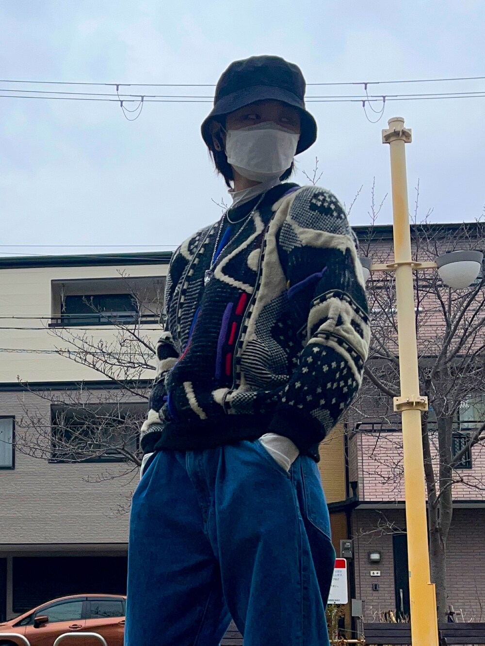 ブルー系のデニムパンツ、その他のニット/セーター、ブラック系のスニーカーを着用したレディースの春コーディネートの2枚目の写真