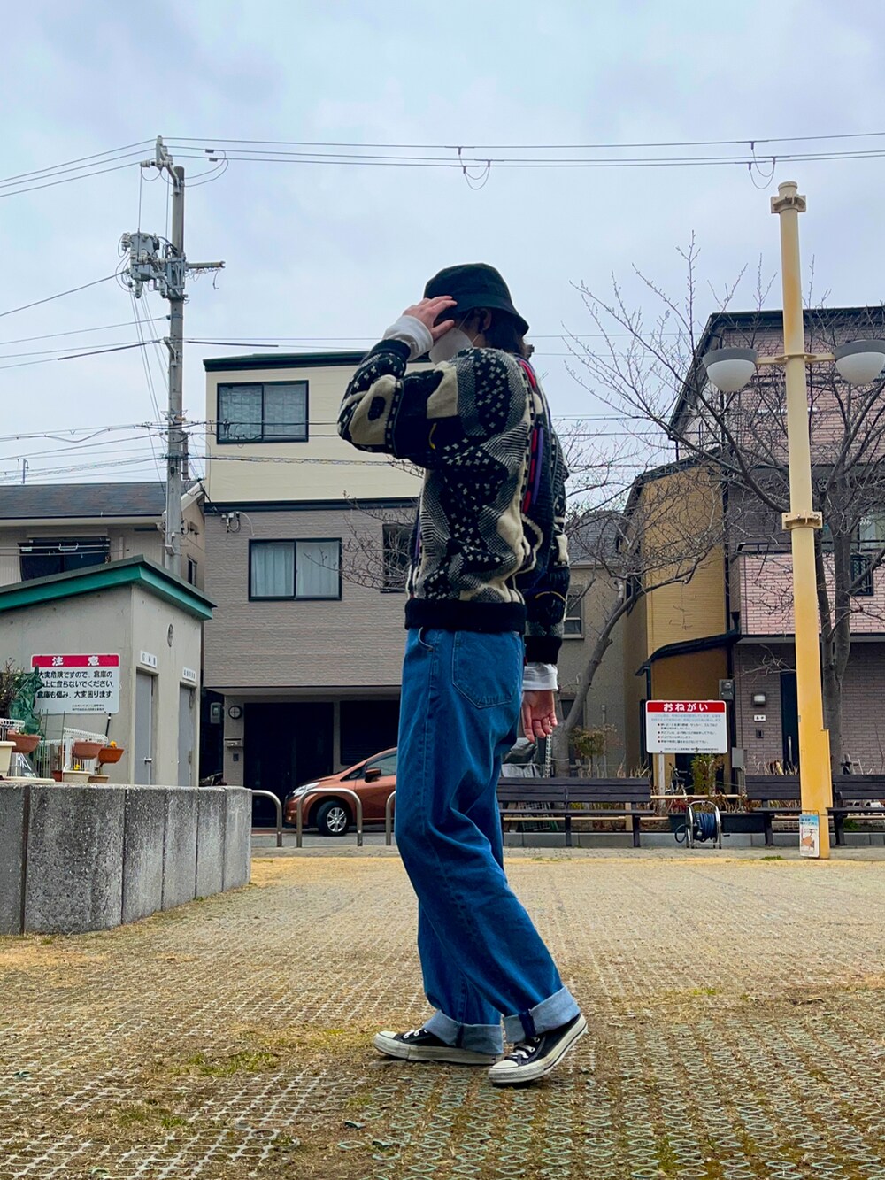 ブルー系のデニムパンツ、その他のニット/セーター、ブラック系のスニーカーを着用したレディースの春コーディネートの3枚目の写真